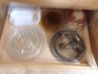 Blurry photo showing Corning Ware bread pan, large glass tray, silver-plated tray and utensils, wooden bowl and other kitchen items.