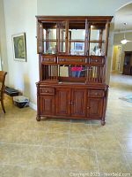 Front view of whole hutch showing glass doors, drawers, and cabinets below.
