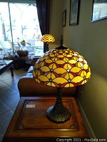 Pair of Tiffany-style resin lamps placed on wooden tables with a living room background, showing overall height and base size.