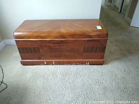 Front view of the antique Lane cedar chest showing the wood veneer and curved lid