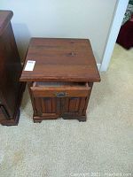 Top-down angle of pine nightstand showing one drawer slightly open and two-door cabinet below.
