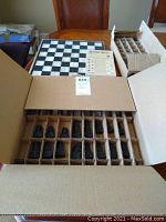 Boxed onyx chess pieces stored in cardboard organizer boxes, 31 pieces visible