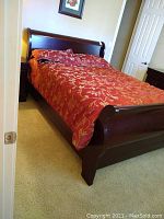 Full view of the queen sleigh bed showing the headboard, footboard, and side rails, with bedding on the mattress.