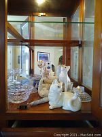 Display cabinet with multiple Lenox cat figurines, crystal bowl, and hobnail candle holders.