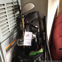 Photo showing black golf club bag filled with various golf clubs including metal and graphite shafts and different club heads