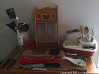Full view of lot showing wooden utensil holder, knives, various kitchen utensils, and storage containers