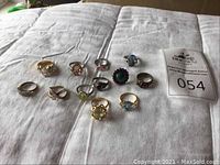 Overview of twelve assorted rings arranged on white cloth