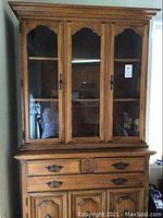 Front view of a solid maple hutch with three glass cabinet doors showing shelves inside the upper section. Three drawers and three cabinets shown in lower section.