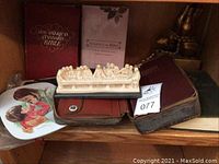 Shelf view of religious items showing Bibles, books, the Last Supper carving, and praying hands statuette.
