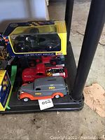 Five model vehicles including boxed 1941 Plymouth truck and PRO Hardware piggy bank vehicle, red delivery truck.