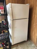 Front and side view of the full refrigerator showing the white exterior and top freezer design.