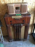 Two radios stacked with the smaller wooden radio cabinet on top and the large Philco radio below, showing overall appearance and size comparison