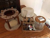 Overview of pipe stand, pipe holder tray with pipes and lighters, glass tobacco jar, and beige men's hat.