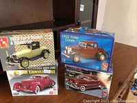 Four AMT model car kit boxes: 1929 Ford Model A Roadster, 1932 Ford Coupe, 37 Cord Convertible, 1951 Chevy Fleetwood
