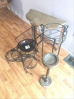 All items together showing demi lune table, metal single and multiple plant stands, wood pillar ashtray stand