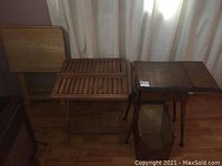 Photo showing the drop leaf side table with drawer, slatted outdoor folding table, wood box table, and a wooden TV table stacked together.