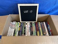 Box containing assorted DVD cases lined up vertically showing the spines with titles.