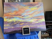 Abstract print on large canvas with vibrant cloudscape colors on blue drape with label lot 38.