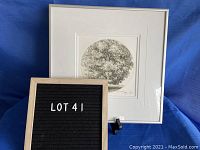 Framed black and white circular print depicting a tree with roots, titled "Tree of Life." Shows the print with white mat and frame.