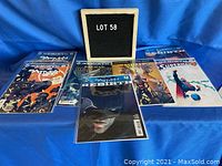 Photo of seven comic books from Batman, Superman, and Spider-Man including close-ups and group shots showing cover art and condition