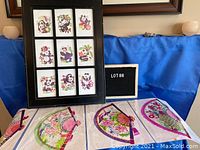 Framed black frame holding nine colorful Chinese paper cut artworks of pandas with flowers and traditional motifs.