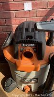 Front view of vacuum showing 5.0 HP and 12 gallon capacity details on the motor housing top and RIDGID brand on the base.