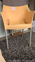 Front view of the "Dr. No" armchair showing beige polypropylene seat and aluminum legs.