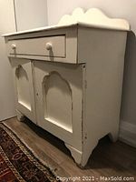 Side view of vintage painted wood hutch showing distressed paint finish and decorative cutout panels on doors.