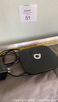 Top view of black Q Plus Android TV box with power adapter and cables