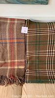 Both blankets side by side, showing plaid patterns, colors, and sizes.
