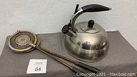 Photo showing the two vintage waffle irons with long handles and the stainless steel kettle with black handle and whistle spout.