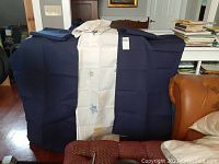 Two sets of kids curtains, displayed draped over a chair and table showing color and pattern details.