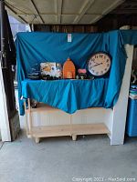 Full lot with antique binoculars, wall clock, lantern, fountain, serving dish, trays, and jar of seashells arranged on cloth