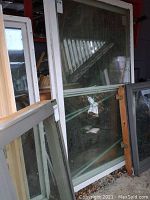 Three large white framed windows stacked together, with glass panes showing dirt and smudges. Horizontal muntin visible on one window.