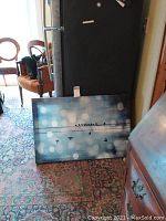 Canvas art laying on floor showing birds on wire design with blue bokeh background.