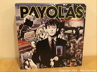 Front cover of Payola$ LP Hammer on a Drum showing collage style artwork with man in suit.