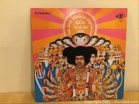 Front cover of Jimi Hendrix - Axis: Bold As Love vinyl album showing colorful psychedelic artwork with multiple arms and faces.