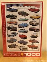 Front view of sealed puzzle box showing image of multiple classic American cars in various colors and styles.