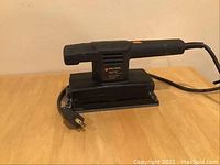 Black & Decker finishing sander with power cord displayed on table