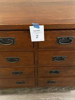 Close-up image showing four of the eight drawers with metal handles and wood grain surface.