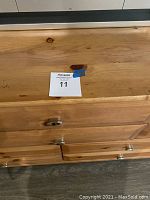 Close-up of dresser surface and drawers showing natural pine wood with knots and metal handles