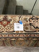 Close-up of rolled rug showing detailed border and hand-crafted knotting pattern