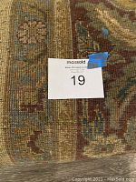 Close-up of floral arabesque pattern and wool texture on rolled edge