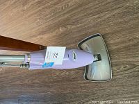 Full view of Shark steam cleaner standing upright on hard floor, showing head attachment and handle