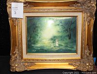 Frontal view of the framed oil painting on metal depicting a person and dogs in a green wooded scene with light shining through trees.