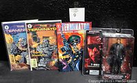 Display of three Terminator comic books alongside sealed Spawn & McFarlane T-850 Terminator action figure with accessories