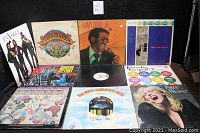 Photo showing part of the vinyl record album lot with visible album covers including Eagles, Sgt. Peppers, Sammy Davis Jr., and others.