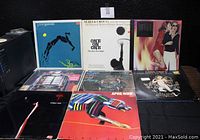 Display of 7 vinyl record albums including Steve Winwood, Seals & Crofts, Genesis, Steely Dan, Peter, Paul & Mary, April Wine, and Sweet.