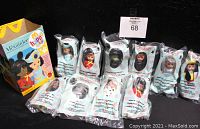 Photo shows 10 sealed Madame Alexander dolls in original plastic packaging accompanied by a folded McDonald's Happy Meal box. Dolls remain mint in package and are numbered with character names visible.