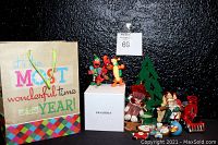 Full view of the Pandora Christmas Spectacular Ball box with many accompanying Christmas-themed figurines and ornaments, all arranged against a black background.